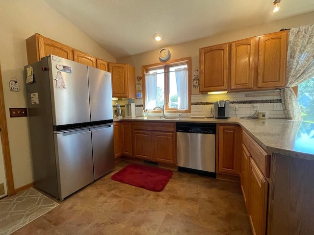 kitchen featuring backsplash, sink, vaulted ceiling, and appliances with stainless steel finishes