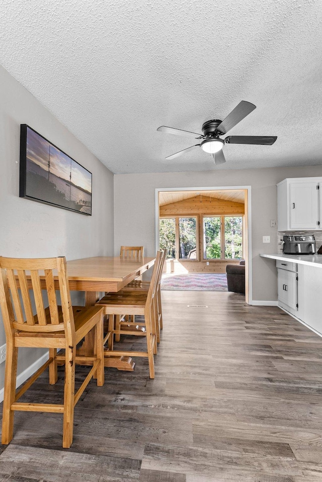 dining area with a textured ceiling, dark hardwood / wood-style floors, and ceiling fan