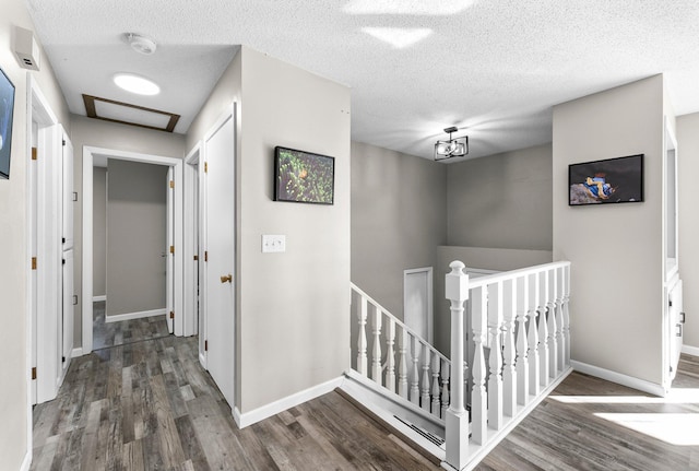 hall with a textured ceiling and dark wood-type flooring