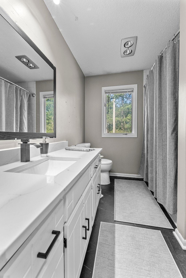 bathroom with a shower with curtain, vanity, plenty of natural light, and toilet