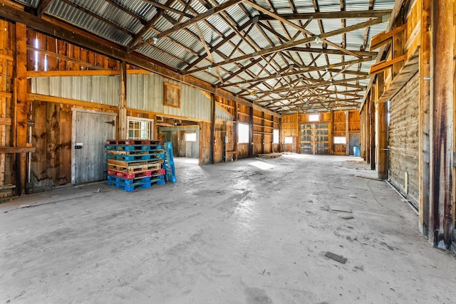 misc room with concrete flooring and high vaulted ceiling