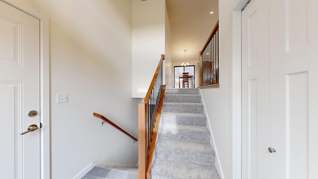 staircase with an inviting chandelier