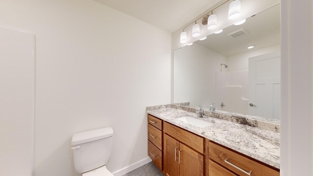 bathroom with vanity, tile patterned flooring, toilet, and walk in shower