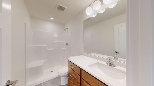 bathroom featuring vanity, a shower, and toilet