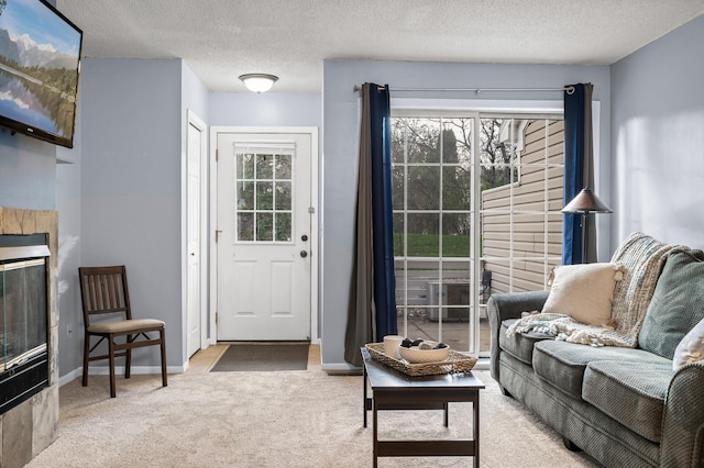 living room with light carpet, a tile fireplace, and a textured ceiling