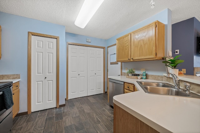 kitchen featuring stainless steel appliances, sink, and a textured ceiling