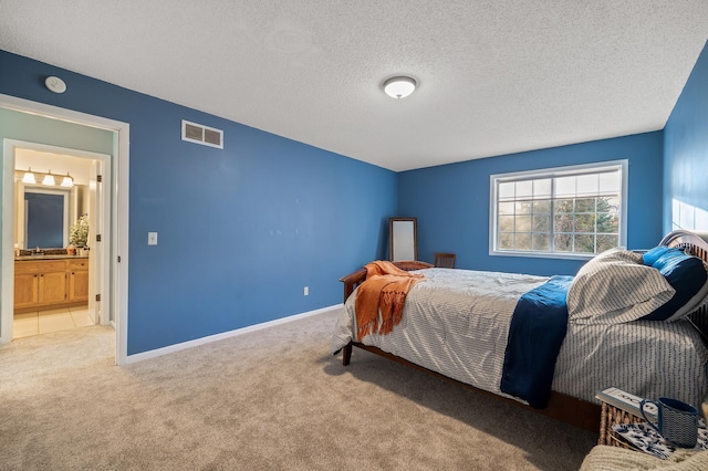 carpeted bedroom featuring sink and a textured ceiling