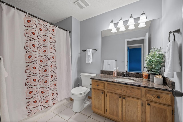 bathroom with vanity, toilet, tile patterned flooring, and a textured ceiling