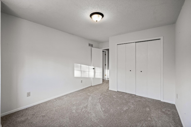 unfurnished bedroom with a closet, a textured ceiling, and carpet