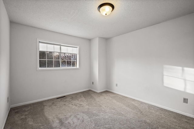 carpeted empty room with a textured ceiling