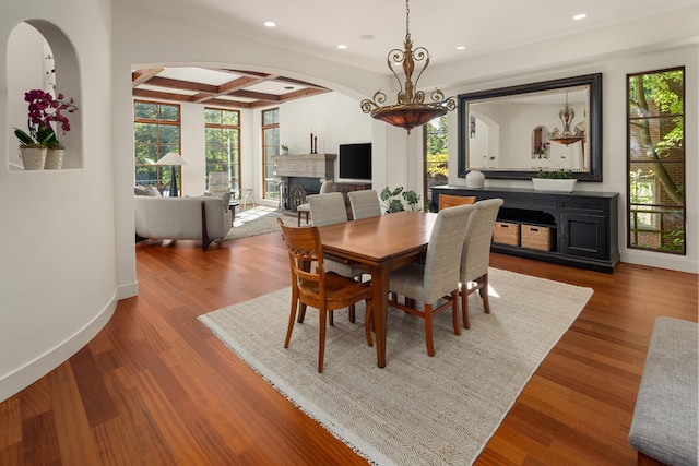 dining room with wood-type flooring, beamed ceiling, and coffered ceiling