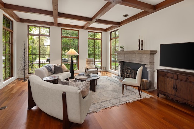 living room with coffered ceiling, light wood-type flooring, and beam ceiling