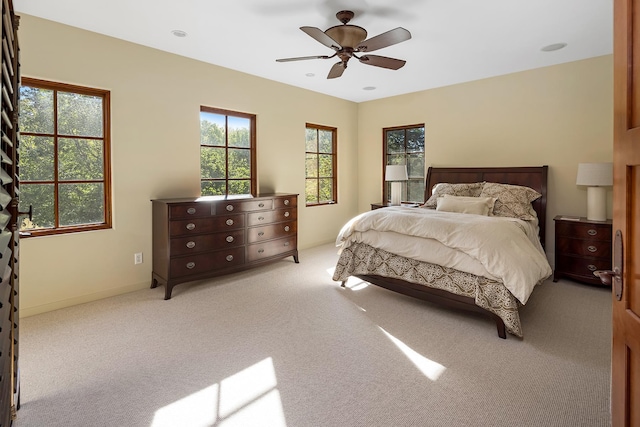 carpeted bedroom with multiple windows and ceiling fan