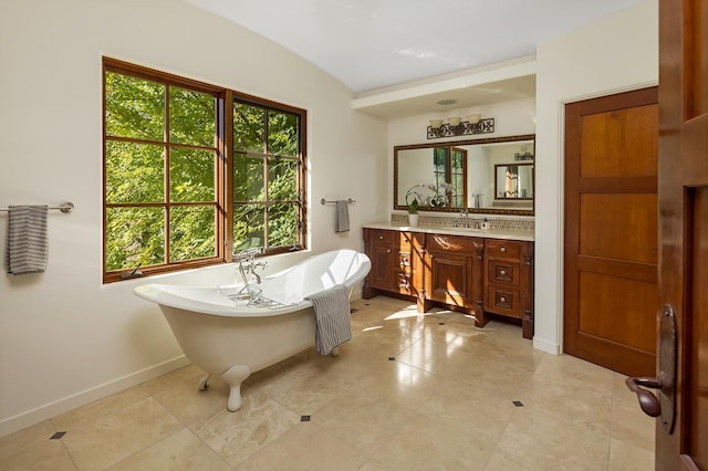 bathroom featuring a bathtub, vaulted ceiling, and vanity