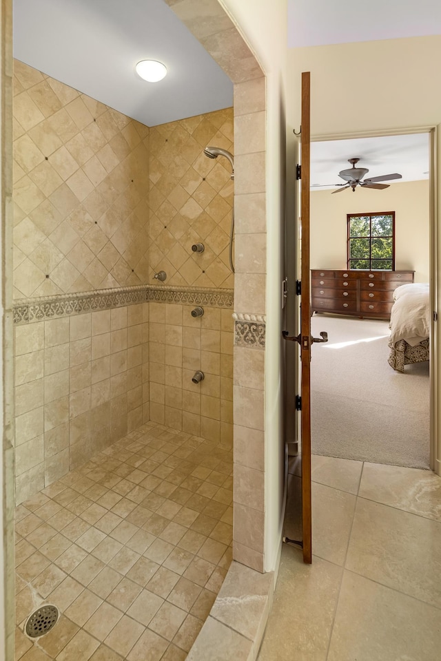 bathroom featuring tile patterned flooring, a tile shower, and ceiling fan