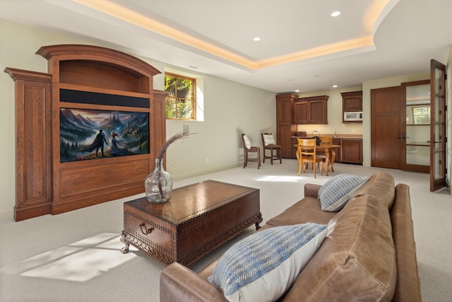 carpeted living room featuring a tray ceiling