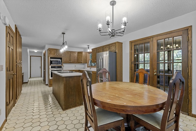 dining space featuring a notable chandelier and a textured ceiling