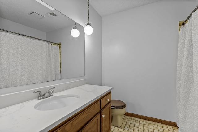 bathroom with vanity, a textured ceiling, toilet, and tile patterned floors