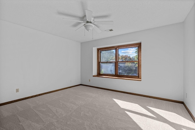 carpeted empty room with ceiling fan and a textured ceiling