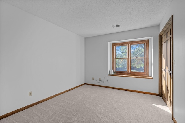 unfurnished bedroom featuring light carpet and a textured ceiling