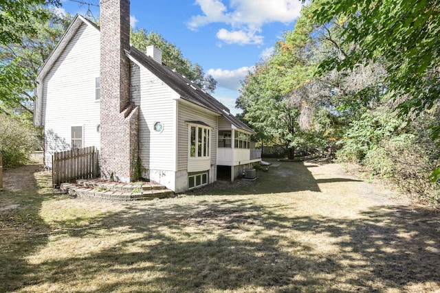 view of side of home with cooling unit and a lawn