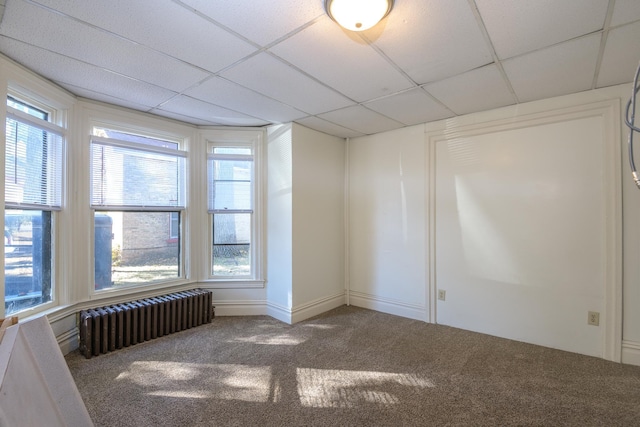 unfurnished room with radiator heating unit, carpet floors, and a wealth of natural light