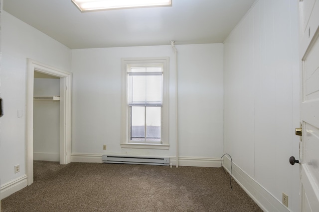 empty room with carpet and a baseboard heating unit