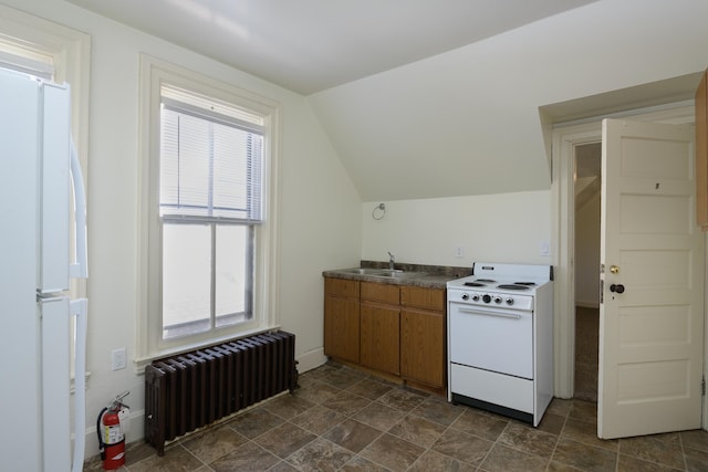 kitchen with lofted ceiling, white appliances, radiator heating unit, and a wealth of natural light