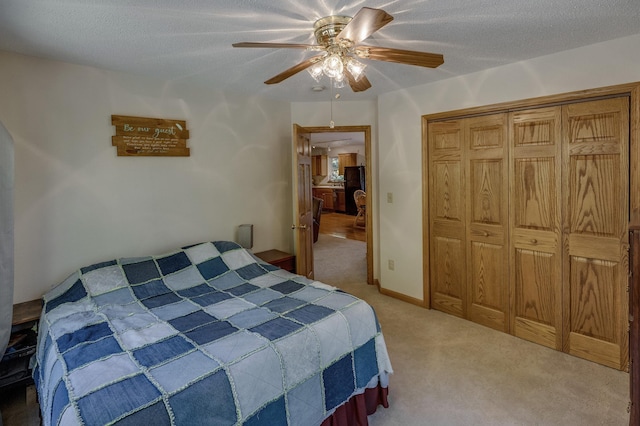 bedroom with carpet flooring, ceiling fan, a closet, and a textured ceiling