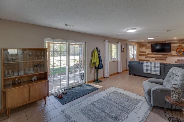 living room featuring light tile patterned flooring and a textured ceiling