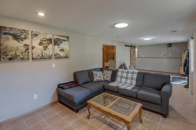 living room with tile patterned floors and a barn door