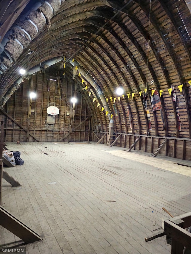 miscellaneous room featuring hardwood / wood-style flooring and vaulted ceiling