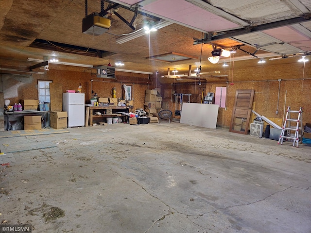 garage with a garage door opener and white refrigerator