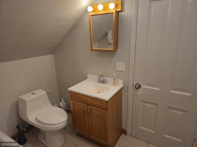 bathroom with vanity, lofted ceiling, toilet, and tile patterned floors