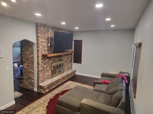 living room featuring a fireplace and dark wood-type flooring