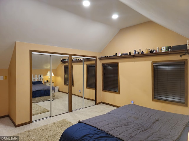 bedroom with lofted ceiling, two closets, and light colored carpet