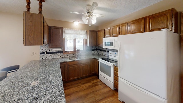kitchen featuring tasteful backsplash, white appliances, a ceiling fan, and brown cabinetry