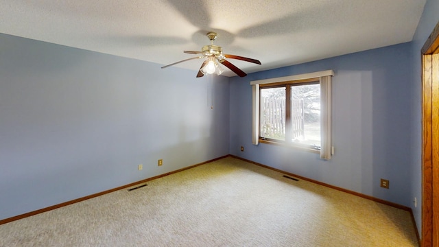 empty room with visible vents, a ceiling fan, baseboards, and carpet floors