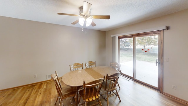 dining room featuring a textured ceiling, light wood-type flooring, and ceiling fan