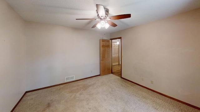 spare room with ceiling fan and carpet