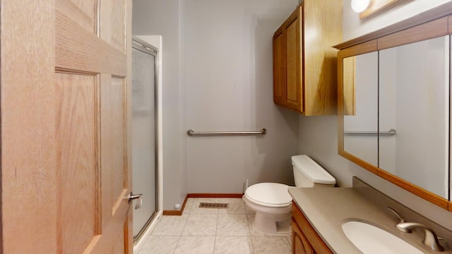 bathroom featuring tile patterned floors, vanity, a shower with door, and toilet