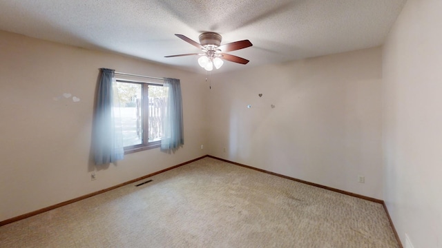 empty room with baseboards, visible vents, a ceiling fan, and light colored carpet
