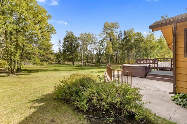 exterior space with a lawn, a deck, and a hot tub