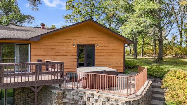 back of house with a wooden deck and a hot tub