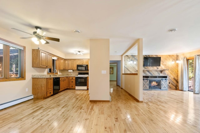 kitchen with light wood-type flooring, black appliances, ceiling fan, sink, and a baseboard heating unit