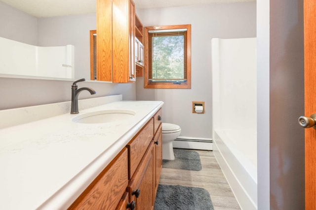 bathroom featuring vanity, baseboard heating, toilet, and hardwood / wood-style flooring