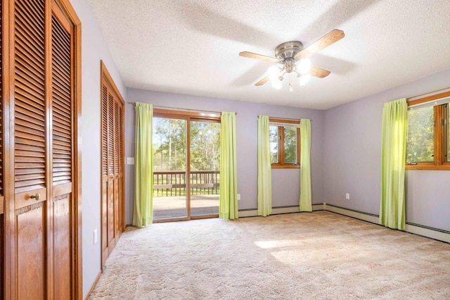 unfurnished bedroom featuring two closets, ceiling fan, light colored carpet, and a textured ceiling