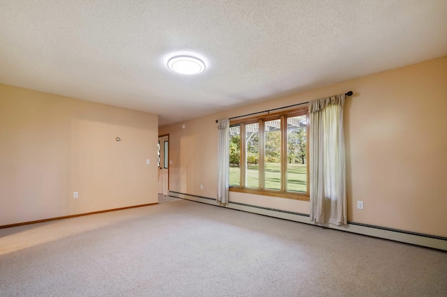 carpeted empty room with a textured ceiling and a baseboard heating unit