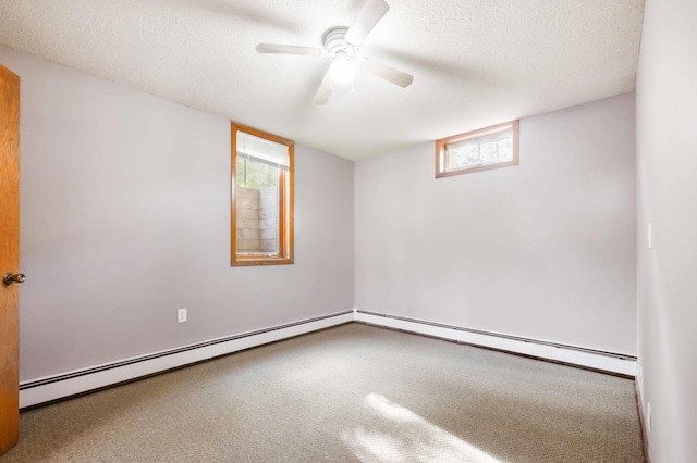 empty room featuring a textured ceiling, a healthy amount of sunlight, ceiling fan, and a baseboard heating unit