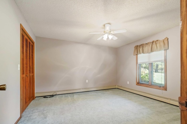 unfurnished room with ceiling fan, light colored carpet, and a textured ceiling